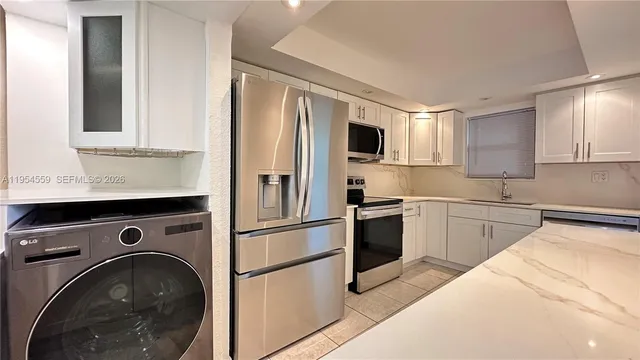 a kitchen with stainless steel appliances granite countertop a refrigerator sink and stove