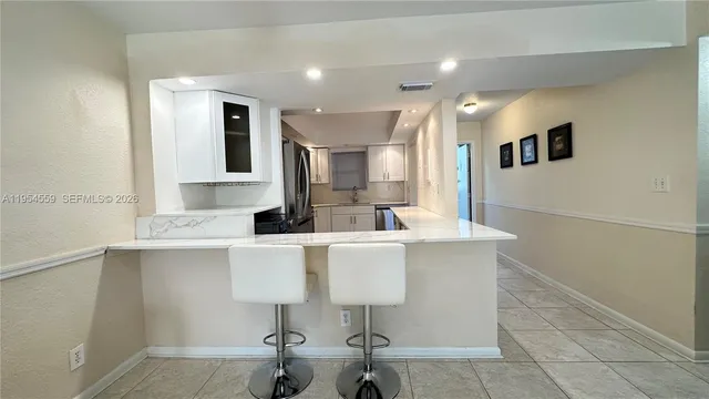 a view of kitchen with kitchen island stainless steel appliances refrigerator stove microwave and cabinets