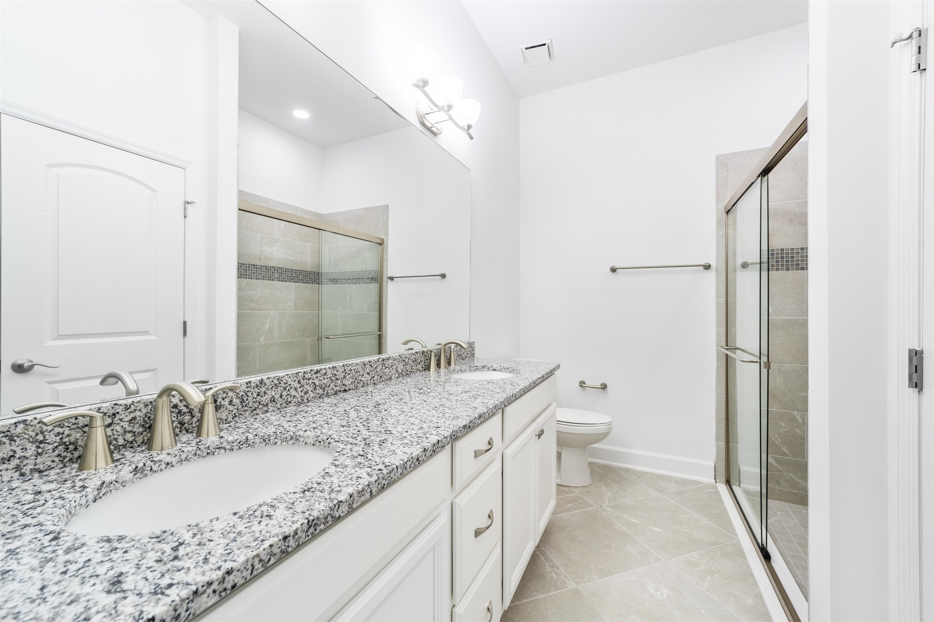 272 Grand Ravine Drive St. Augustine, FL 32086 - Photo 17 of 41 a bathroom with a granite countertop sink a toilet and a large mirror