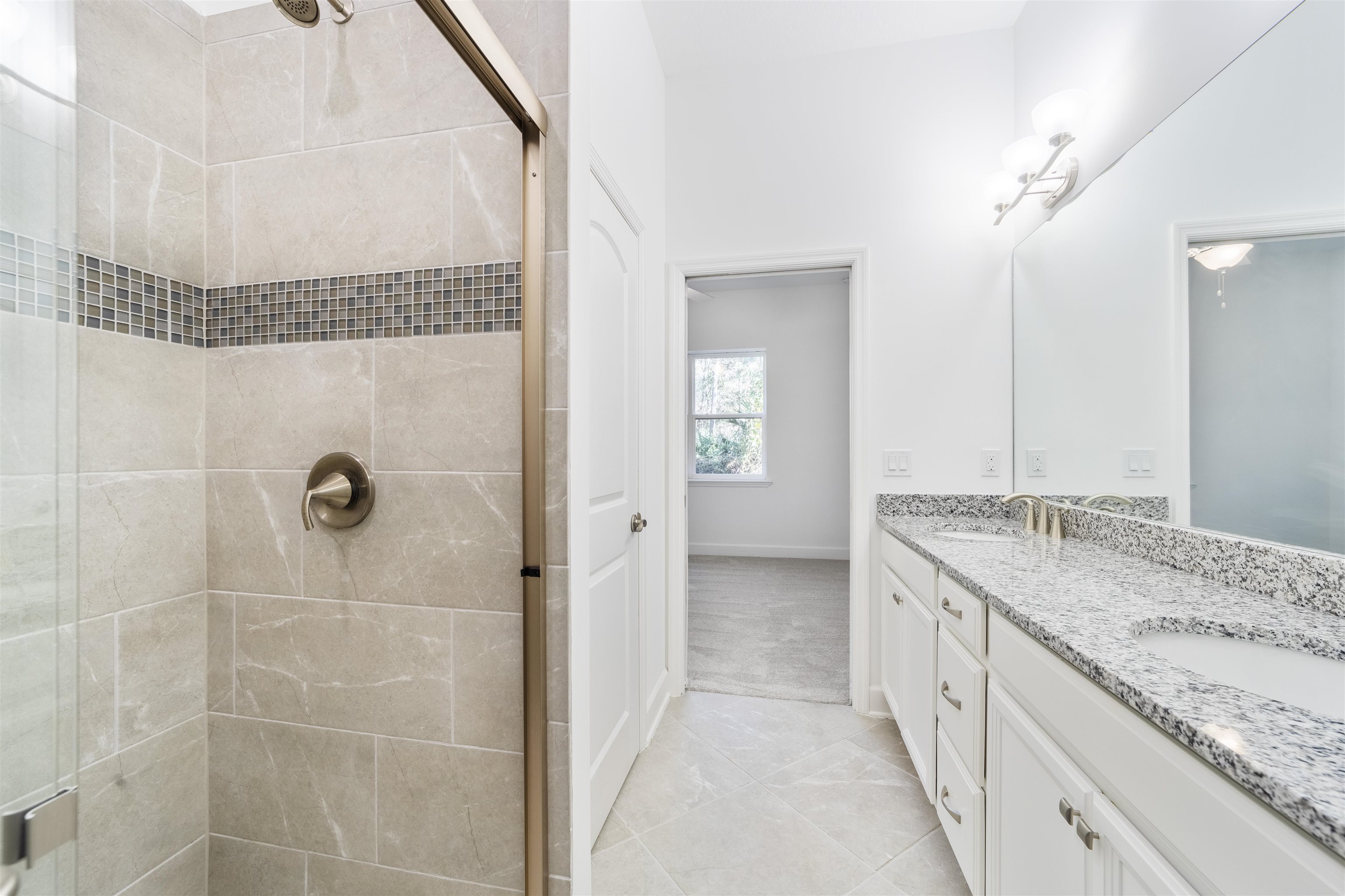 272 Grand Ravine Drive St. Augustine, FL 32086 - Photo 18 of 41 a bathroom with a granite countertop sink a mirror and a shower