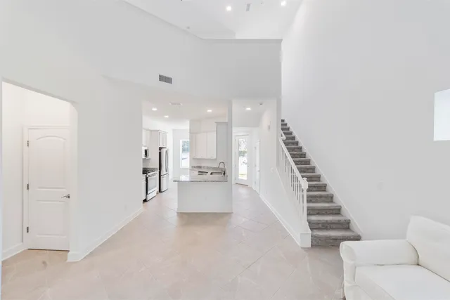 a view of a living room filled with furniture and stairs