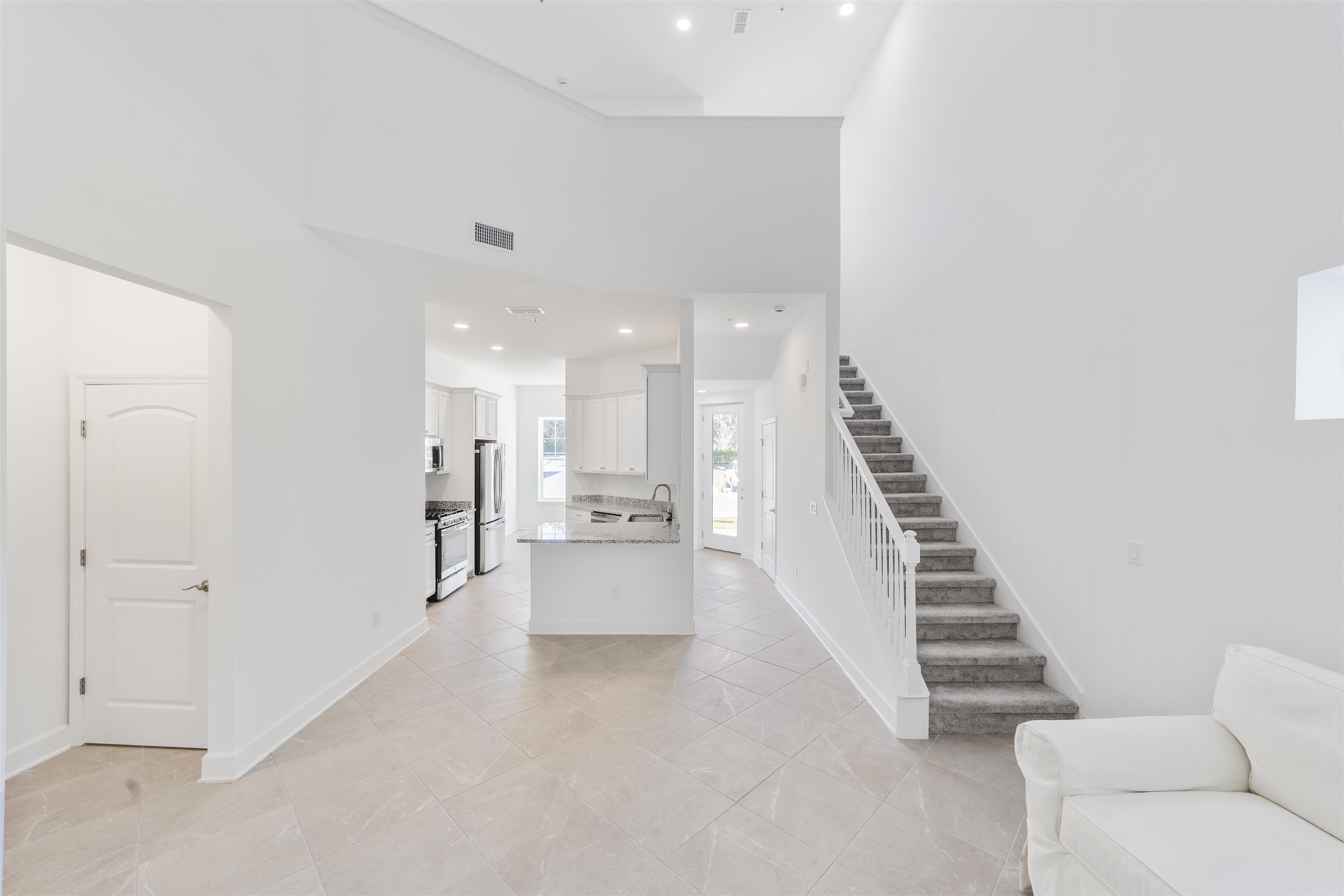 272 Grand Ravine Drive St. Augustine, FL 32086 - Photo 19 of 41 a view of a living room filled with furniture and stairs