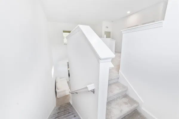 a view of a hallway with white walls and entryway