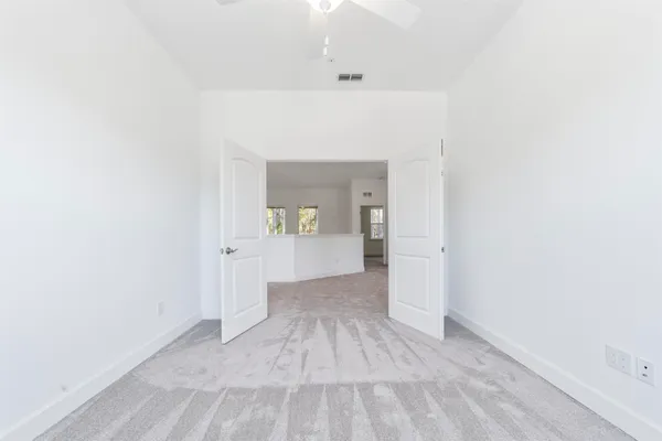 a view of a hallway with wooden floor and a bathroom