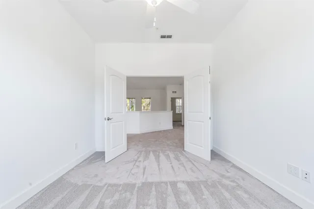 a view of a hallway with wooden floor and a bathroom