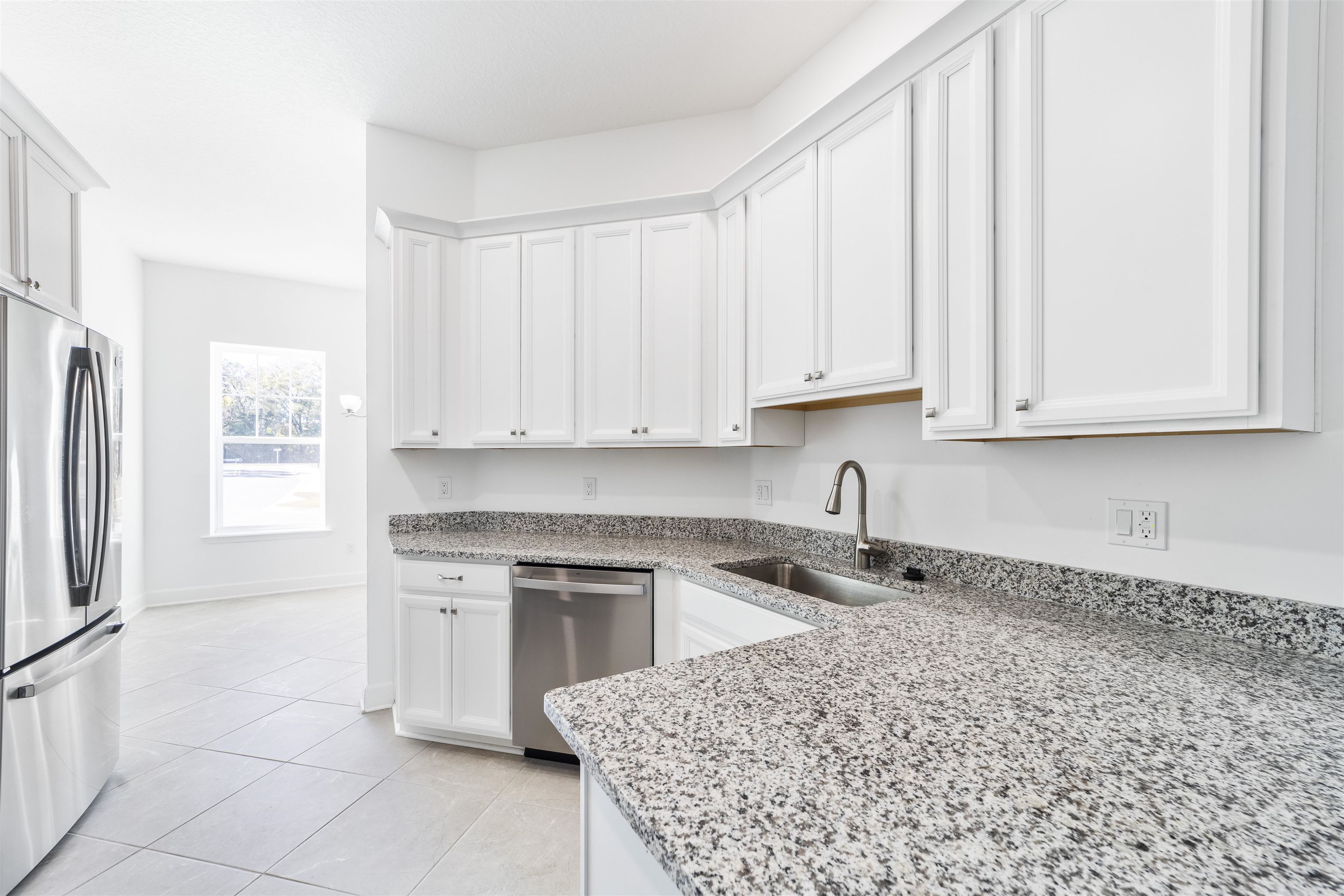 272 Grand Ravine Drive St. Augustine, FL 32086 - Photo 8 of 41 a kitchen with stainless steel appliances granite countertop a sink a stove a refrigerator and white cabinets with wooden floor