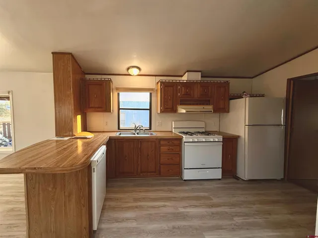 a kitchen with stainless steel appliances granite countertop a refrigerator a sink and a stove