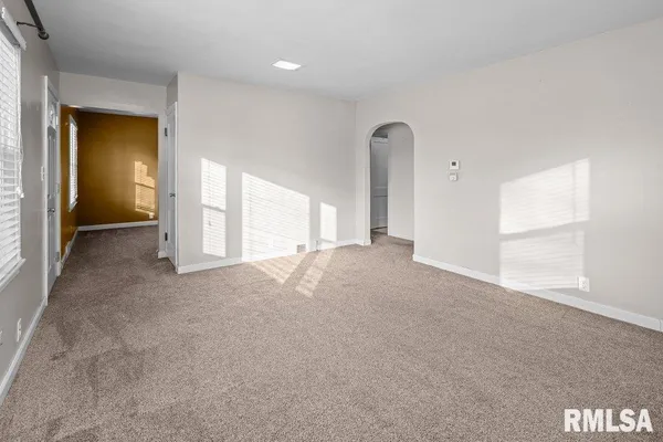 an empty room with windows and closet