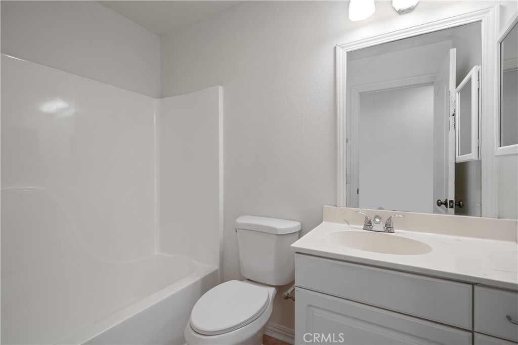 29582 Toomas Circle Menifee, CA 92587 - Photo 12 of 30 a white toilet sitting next to a bathroom sink