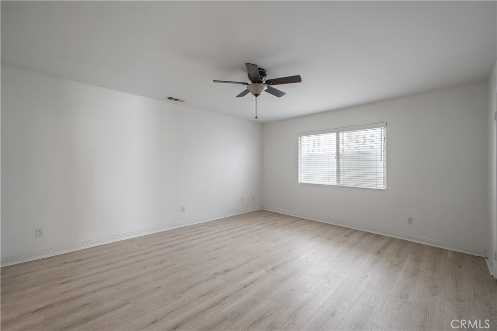 29582 Toomas Circle Menifee, CA 92587 - Photo 15 of 30 an empty room with wooden floor ceiling fan and windows