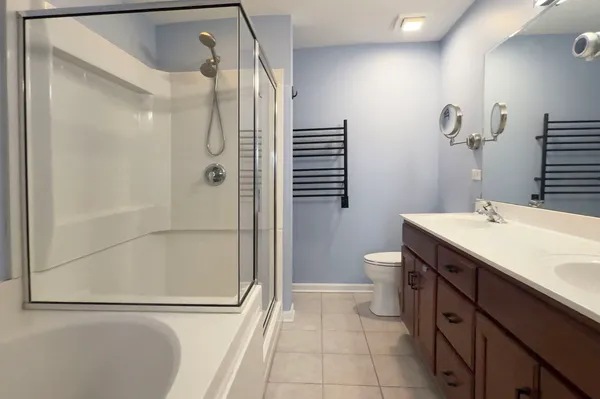 a bathroom with a double vanity sink toilet and shower