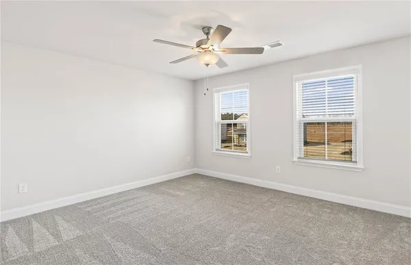 an empty room with window and ceiling fan