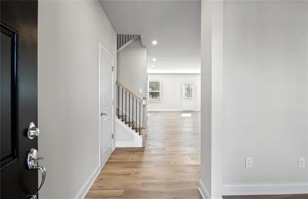 a view of a hallway with wooden floor and entryway