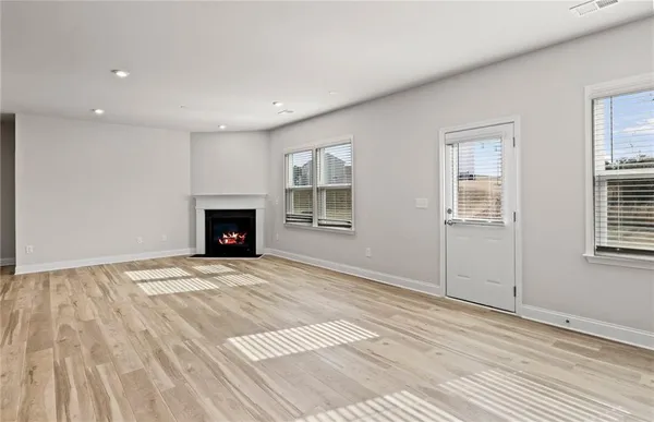 a view of an empty room with a window and fireplace