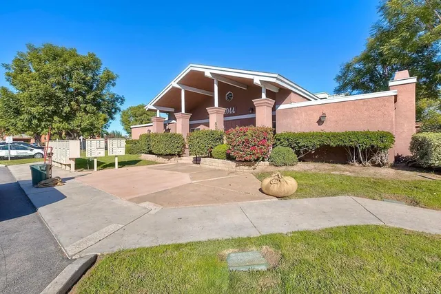 a view of a house with backyard and trees