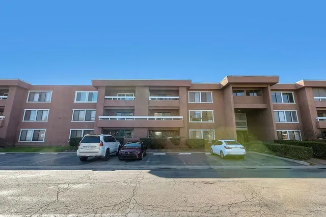 a front view of a residential apartment building with a yard