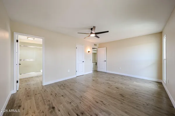 a view of a livingroom with wooden floor and a ceiling fan