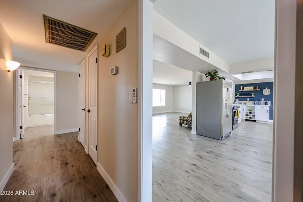 a view of hallway with wooden floor and closet