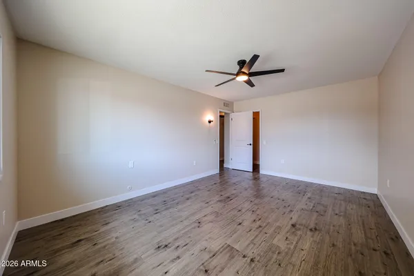 a view of a room with wooden floor and ceiling fan