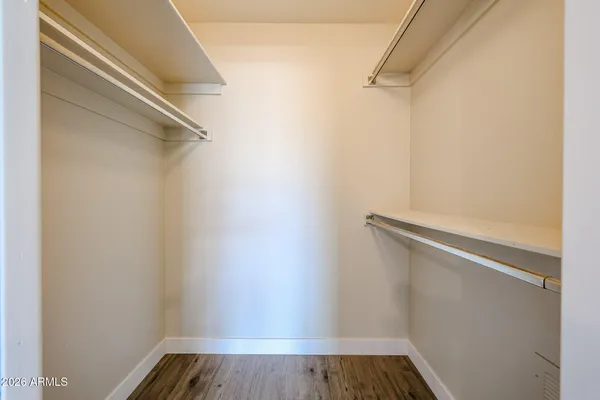 a view of walk in closet with wooden floor