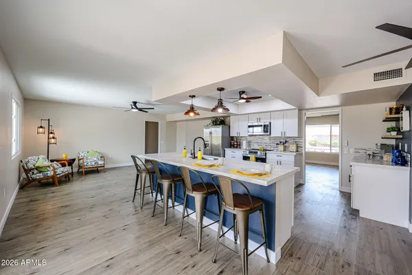 a room with stainless steel appliances lots of wooden furniture and wooden floor