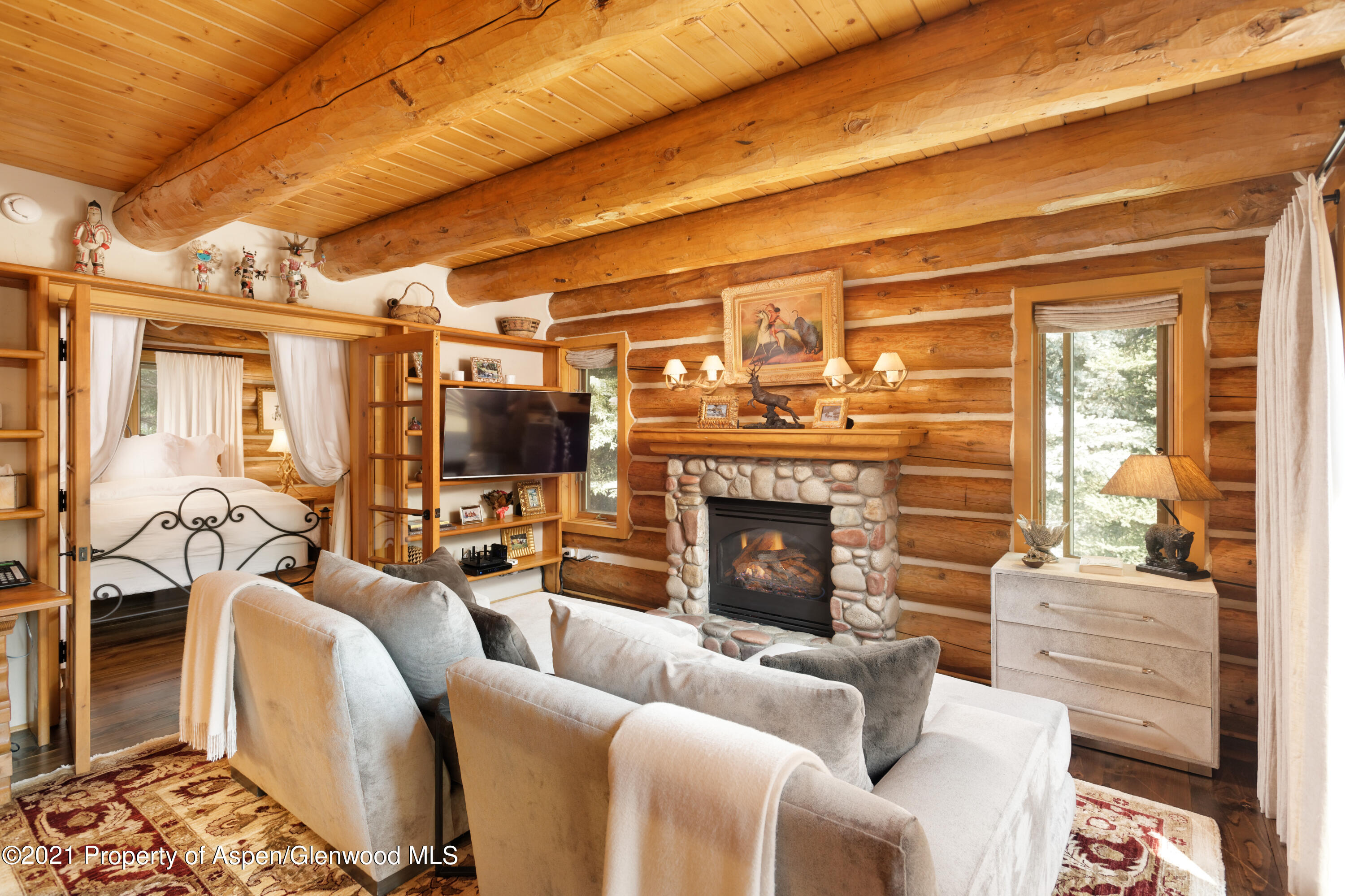 770 Twining Flats Road Woody Creek, CO 81611 - Photo 18 of 59 a living room with furniture a flat screen tv and a fireplace