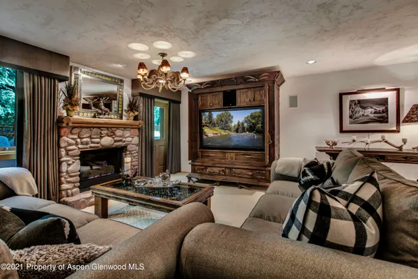 a living room with furniture a flat screen tv and a window