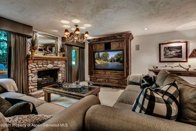 a living room with furniture a flat screen tv and a window
