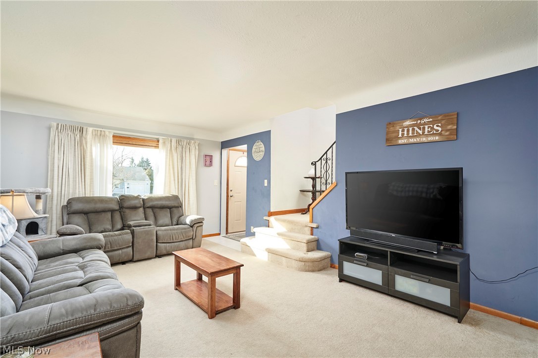 1359 Beaconfield Road Lyndhurst, OH 44124 - Photo 12 of 26 Carpeted living area featuring stairs and baseboards