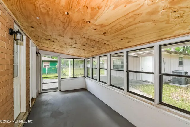 a view of an empty room with a fireplace and a window
