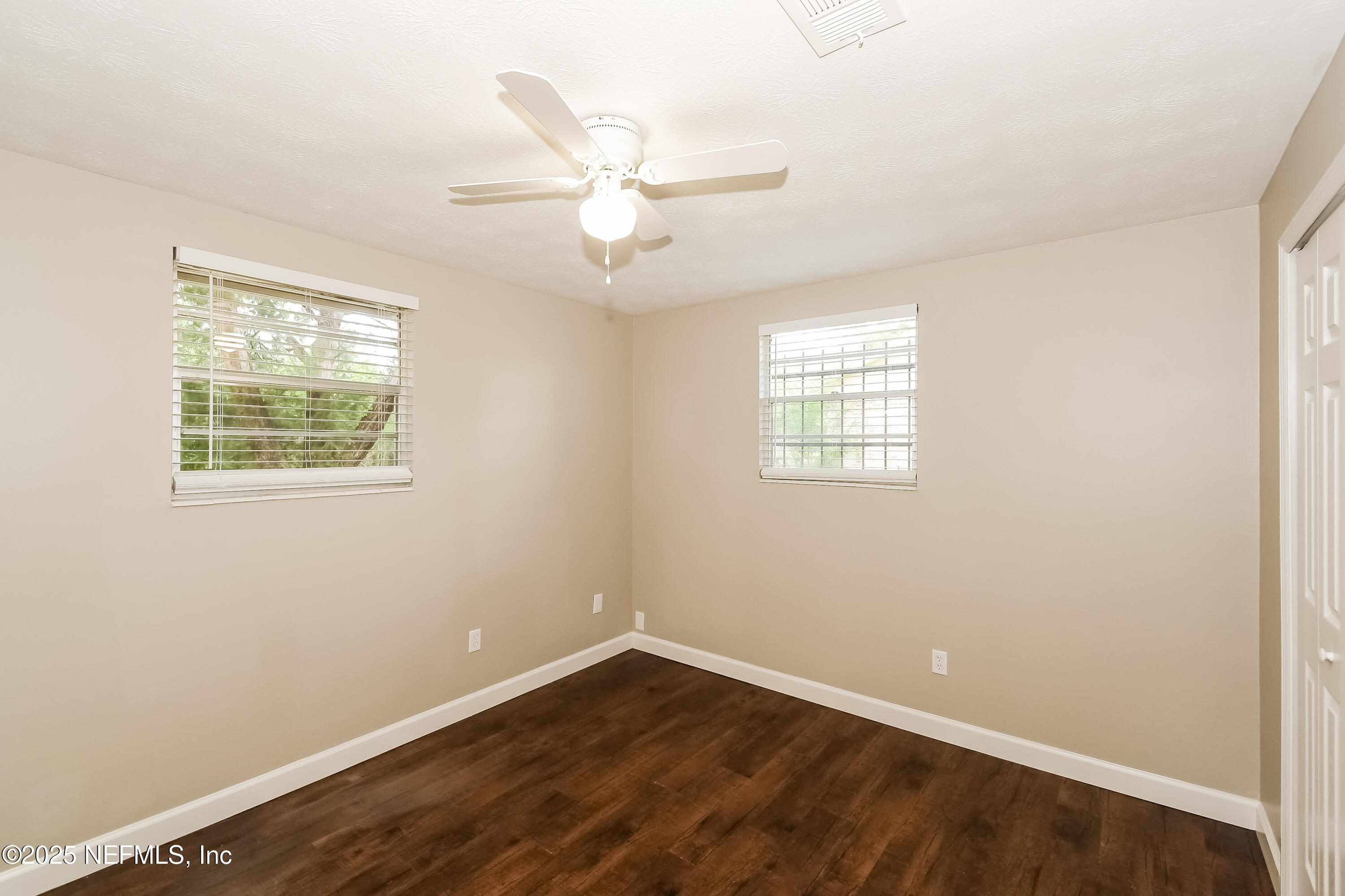 10632 Pinholster Road Jacksonville, FL 32218 - Photo 7 of 15 an empty room with wooden floor fan and windows