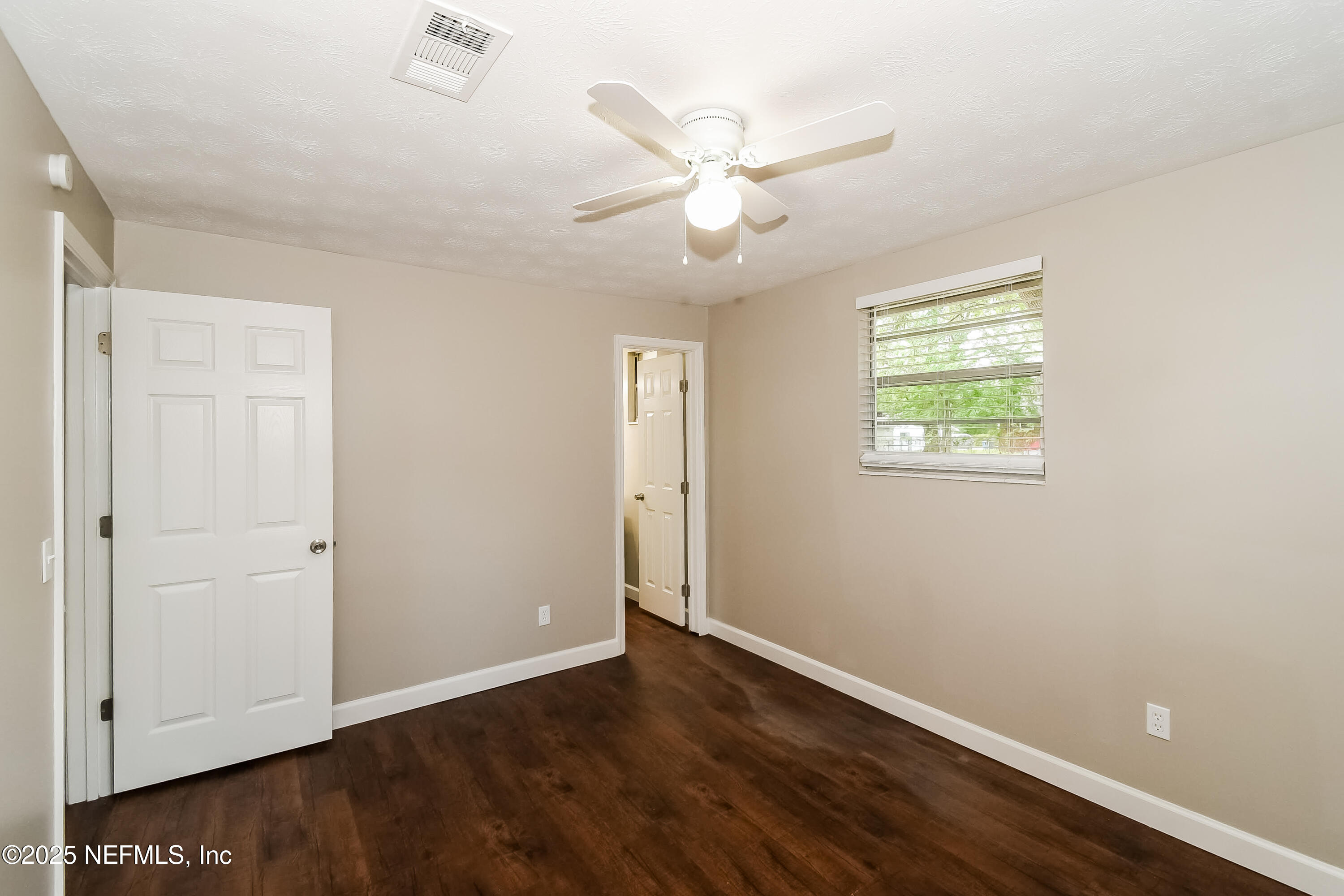 10632 Pinholster Road Jacksonville, FL 32218 - Photo 8 of 15 an empty room with wooden floor closet and windows