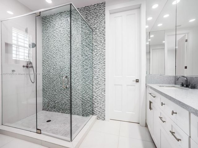 a bathroom with a shower sink and mirror