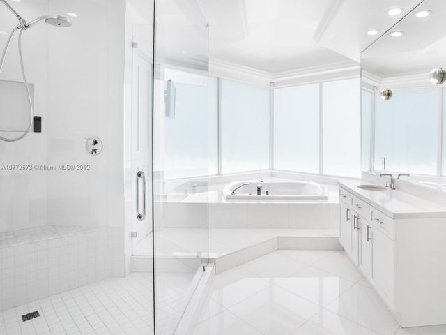 a large bathroom with a tub sink shower and mirror