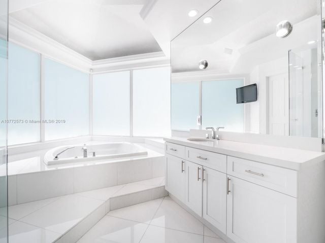 a bathroom with a tub sink and mirror