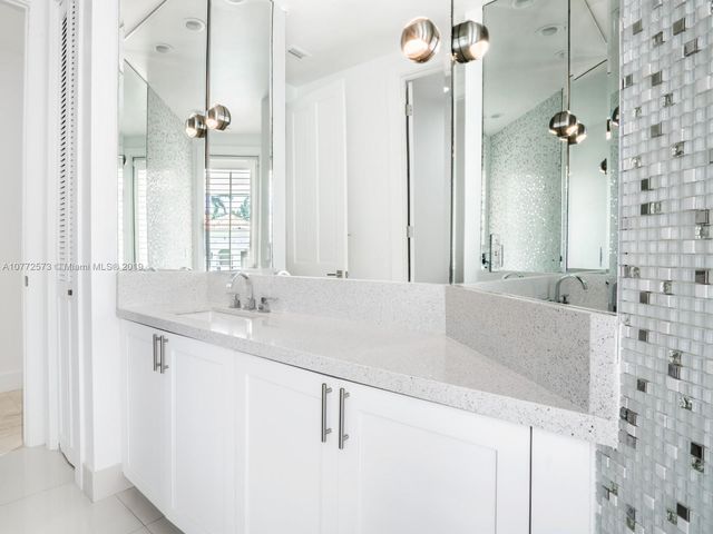 a bathroom with a granite countertop sink a toilet a mirror and shower
