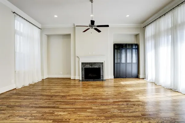 a view of empty room with ceiling fan and window
