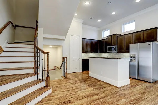 a kitchen with stainless steel appliances kitchen island granite countertop a refrigerator and a stove top oven