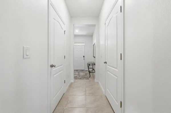 a hallway with white doors wooden cabinet and a bathroom