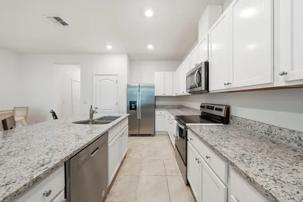 a kitchen with stainless steel appliances granite countertop a sink stove and cabinets