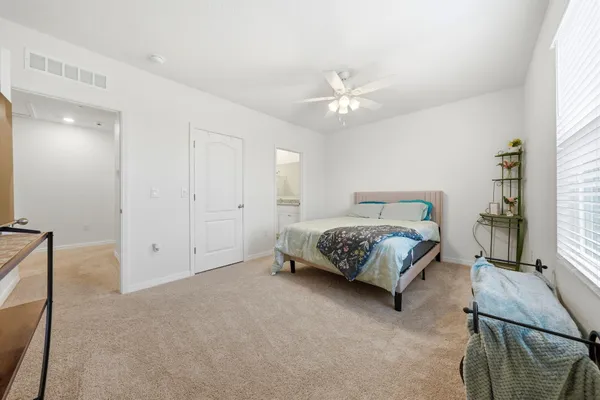 a bedroom with a large bed and a chandelier