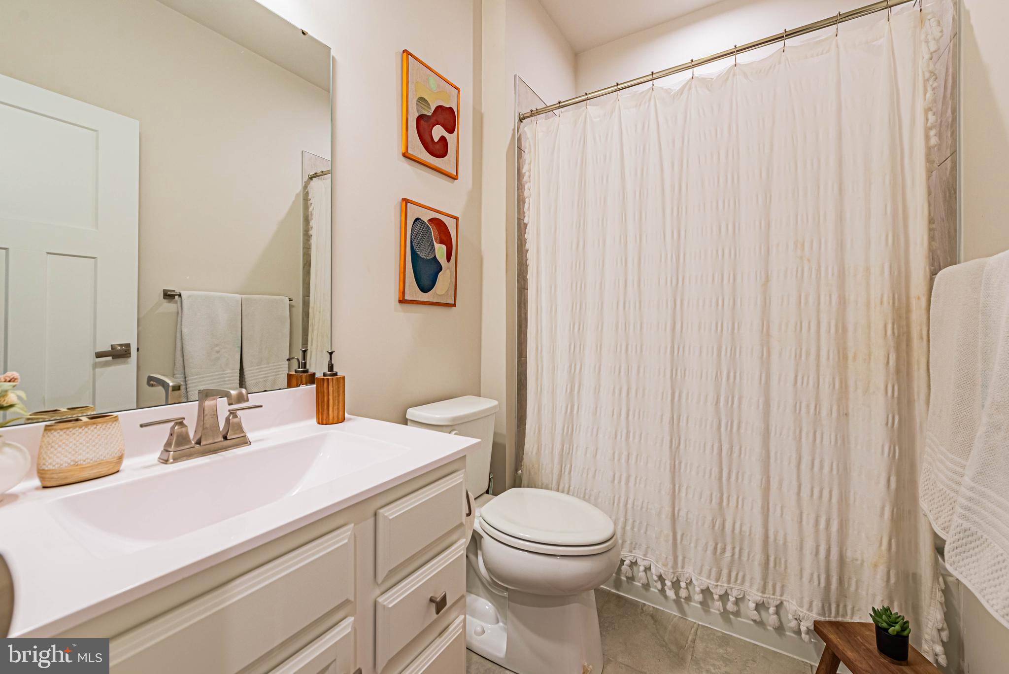 12115 Snug Harbor Road Berlin, MD 21811 - Photo 21 of 46 a bathroom with a sink a toilet and shower curtain