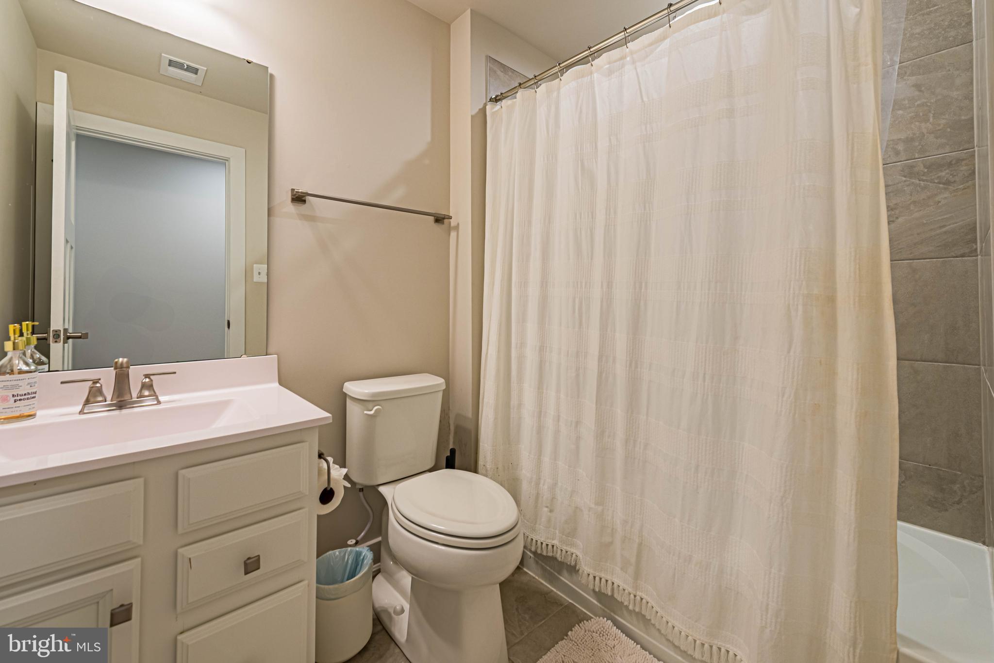 12115 Snug Harbor Road Berlin, MD 21811 - Photo 33 of 46 a bathroom with a sink a toilet and shower curtain
