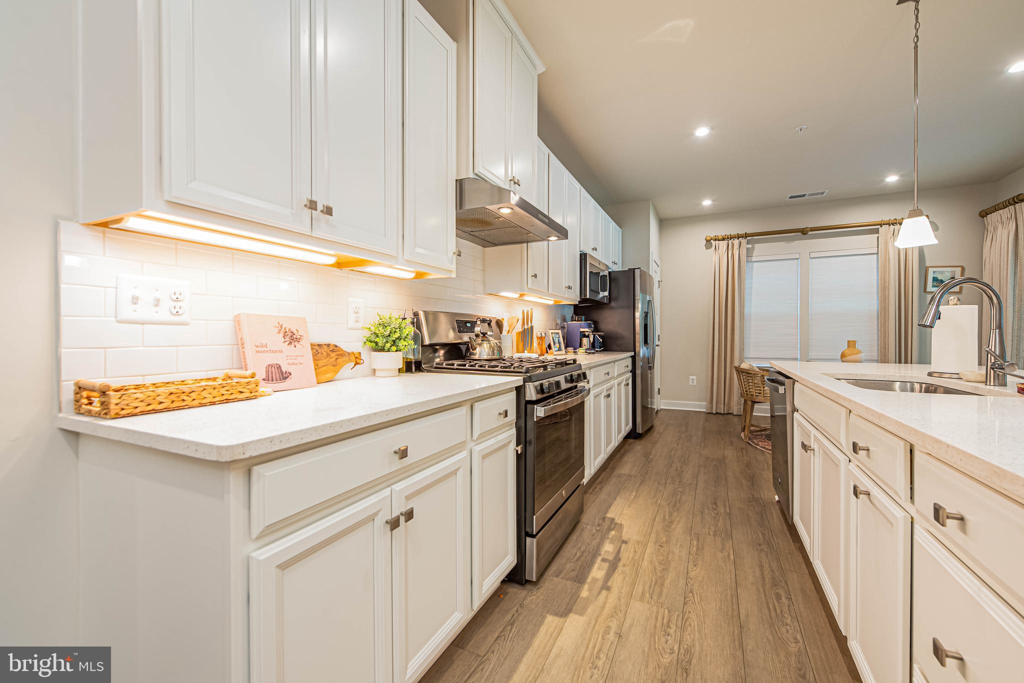 12115 Snug Harbor Road Berlin, MD 21811 - Photo 6 of 46 a kitchen with a sink stove and cabinets