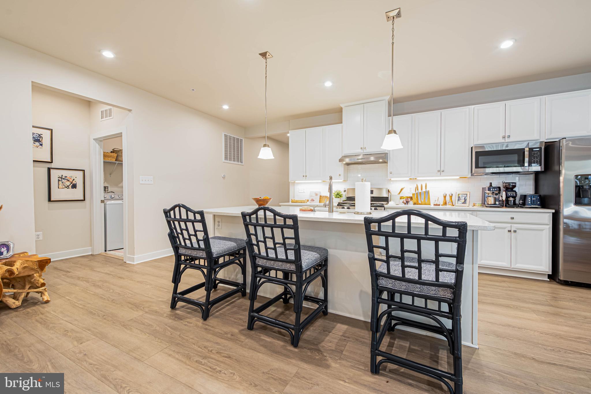 12115 Snug Harbor Road Berlin, MD 21811 - Photo 10 of 46 a kitchen with stainless steel appliances a dining table chairs refrigerator and cabinets