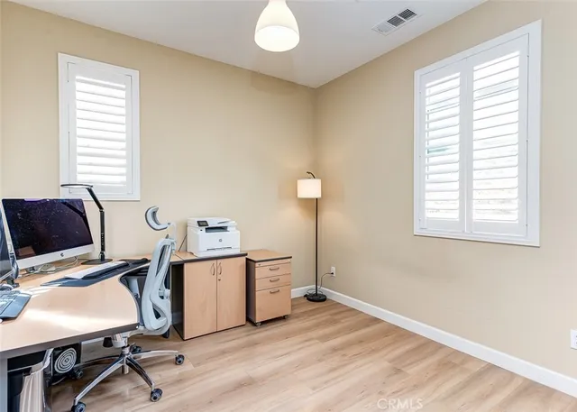 a view of a workspace with furniture and a window