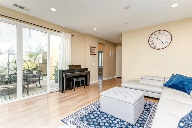 a living room with furniture a clock and a large window