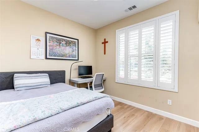 a bedroom with a bed wall painting and a window