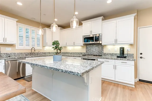 a kitchen with stainless steel appliances granite countertop a sink a stove and a microwave
