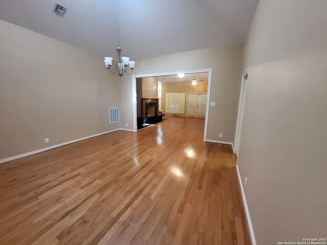 a view of a room with wooden floor and chandelier